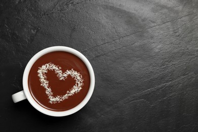 Photo of Cup of hot chocolate with heart shaped decoration on black table, top view. Space for text