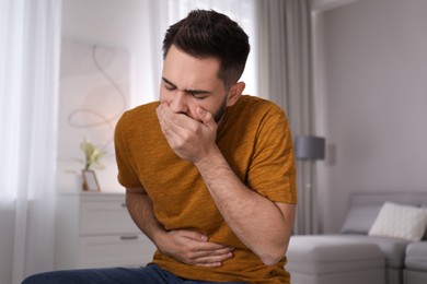 Young man suffering from nausea at home. Food poisoning