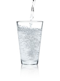 Pouring soda water into glass on white background