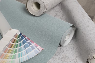 Wall paper rolls and color palette on wooden floor