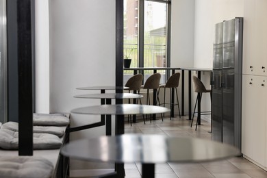Hostel dining room interior with modern furniture and refrigerators