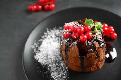 Delicious warm chocolate lava cake with mint and berries on table, closeup. Space for text