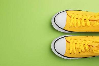 Photo of Pair of trendy sneakers on green background, flat lay. Space for text