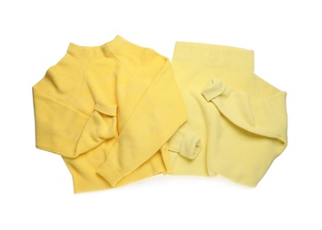 Photo of Yellow woolen sweaters on white background, top view