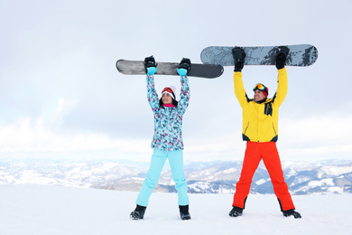 Lovely couple with snowboards on hill. Winter vacation