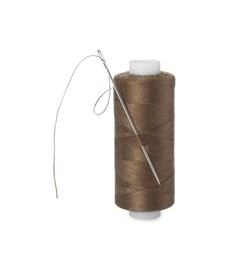 Spool of brown sewing thread with needle isolated on white