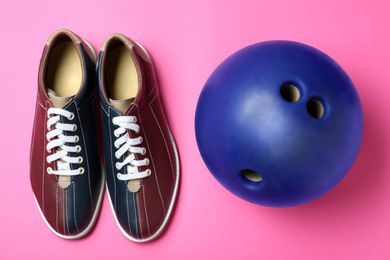 Bowling ball and shoes on pink background, flat lay