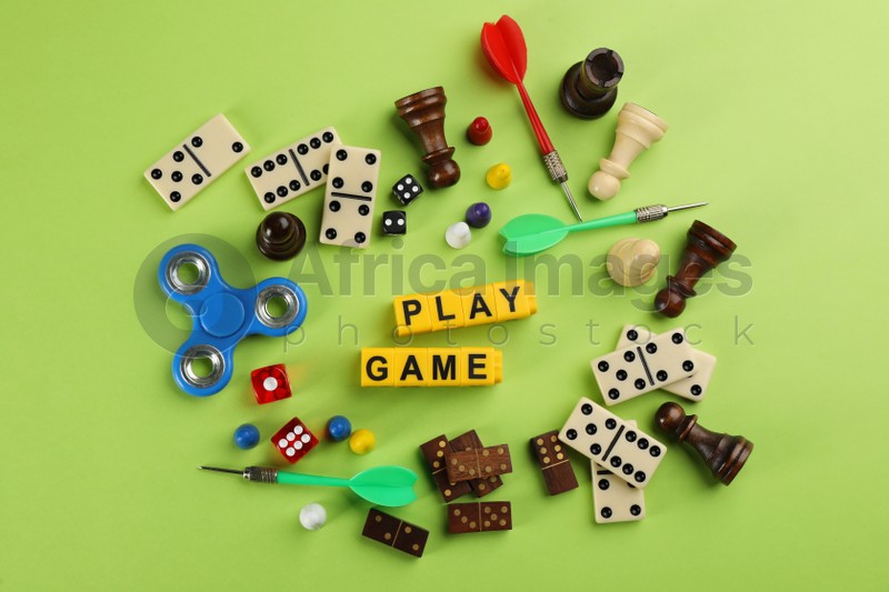 Flat lay composition of blocks with words Play Game on green background