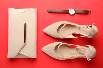 Flat lay composition with stylish women's shoes and accessories on red background