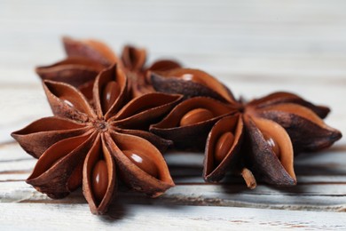 Aromatic anise stars on white wooden table, closeup