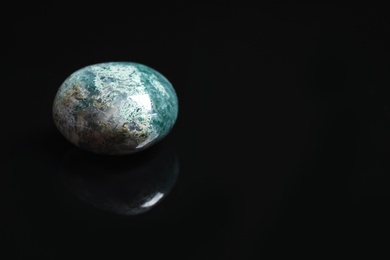 Photo of Beautiful moss agate gemstone on black background. Space for text