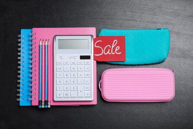 Flat lay composition with school stationery and word Sale on blackboard