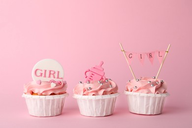 Baby shower cupcakes with toppers on pink background