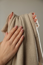 Photo of Woman with cashmere sweater on beige background, closeup