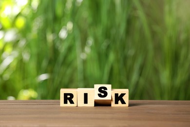 Cubes with word Risk on wooden table
