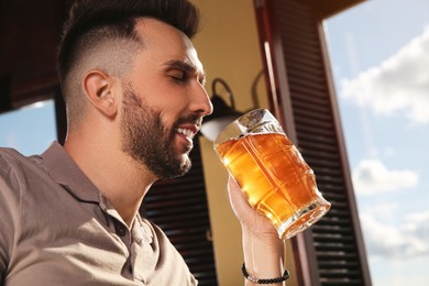 Bearded man drinking tasty beer in pub