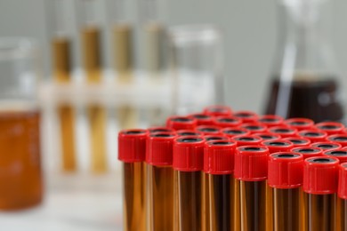 Photo of Different laboratory glassware with brown liquids, closeup. Space for text