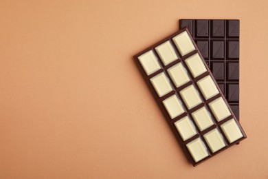 Photo of Tasty chocolate bars on brown background, flat lay. Space for text