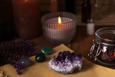 Composition with healing amethyst gemstone on table