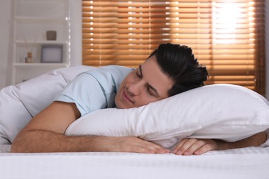Man sleeping in comfortable bed with white linens