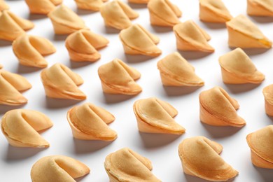 Many tasty fortune cookies with predictions on white background