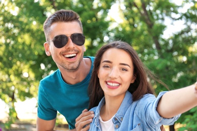 Young couple taking selfie outdoors on sunny day