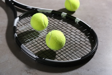 Tennis racket and balls on grey table. Sports equipment