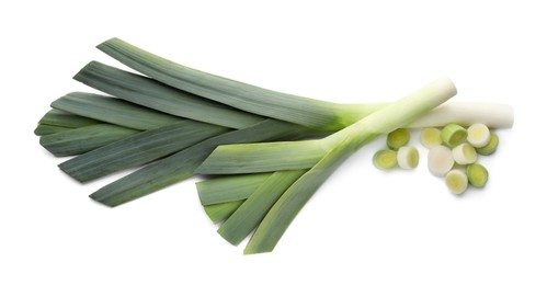 Whole and cut fresh leeks on white background, top view