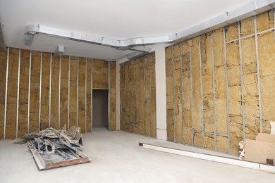 Wall with metal studs and insulation material indoors. Repair and maintenance