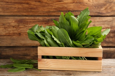 Fresh green sorrel leaves in crate on wooden table