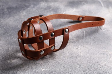 Photo of Brown leather dog muzzle on light gray textured table
