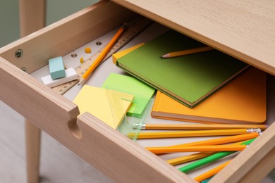 Photo of Office supplies in open desk drawer indoors, closeup