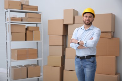 Young man near cardboard boxes at warehouse