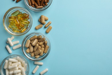 Photo of Different dietary supplements on light blue background, flat lay. Space for text