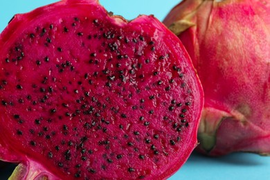 Delicious cut red pitahaya fruit on light blue background, closeup