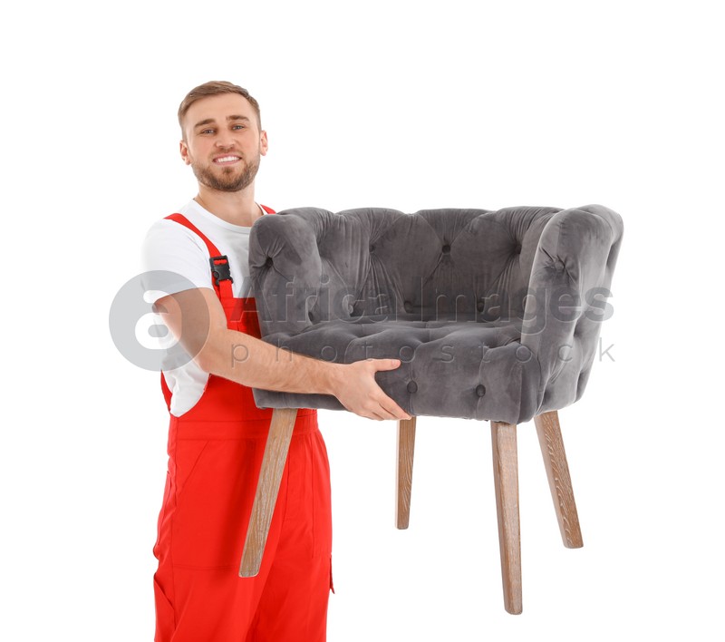 Young worker carrying armchair isolated on white. Moving service