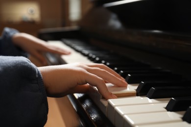 Little child playing piano, closeup. Music lesson