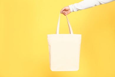 Young man with eco bag on yellow background, closeup
