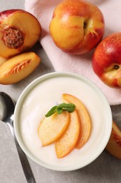 Photo of Delicious yogurt with fresh peach and mint on grey table, flat lay