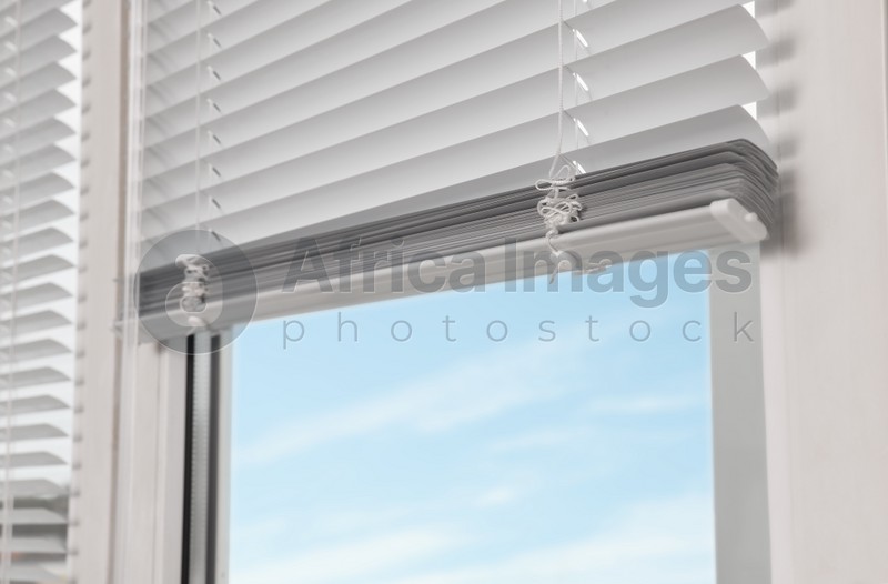 Photo of Stylish window with horizontal blinds, closeup view