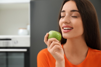 Concept of choice between healthy and junk food. Woman with apple in kitchen