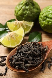 Photo of Dry bergamot tea leaves and fresh fruits on wooden table, closeup