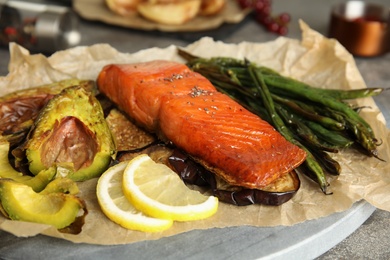 Photo of Tasty cooked salmon and vegetables served on grey table, closeup. Healthy meals from air fryer