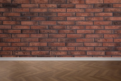 Image of Wooden floor and empty brick wall indoors