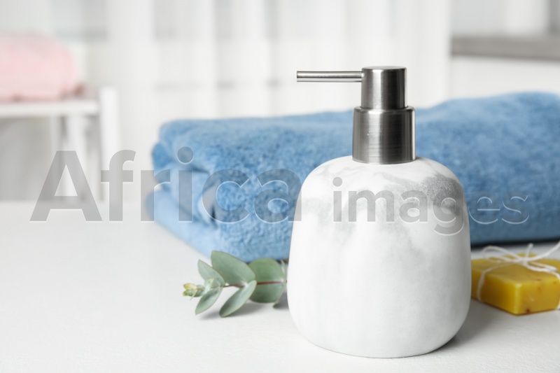 Marble dispenser, eucalyptus and soap bar on white table