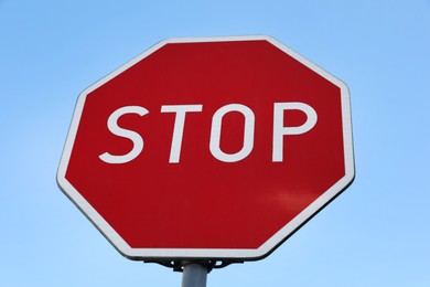 Traffic sign Stop against blue sky, low angle view