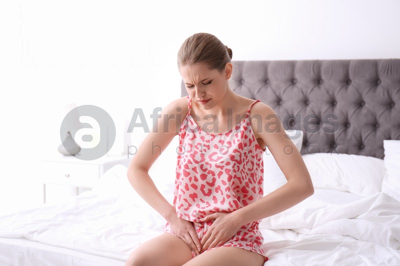 Young woman suffering from menstrual cramps at home. Gynecology