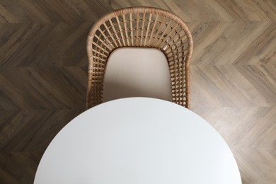 Round table and wicker armchair indoors, top view