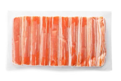 Delicious crab sticks in plastic packaging isolated on white, top view