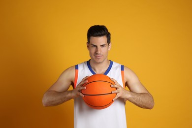 Basketball player with ball on yellow background